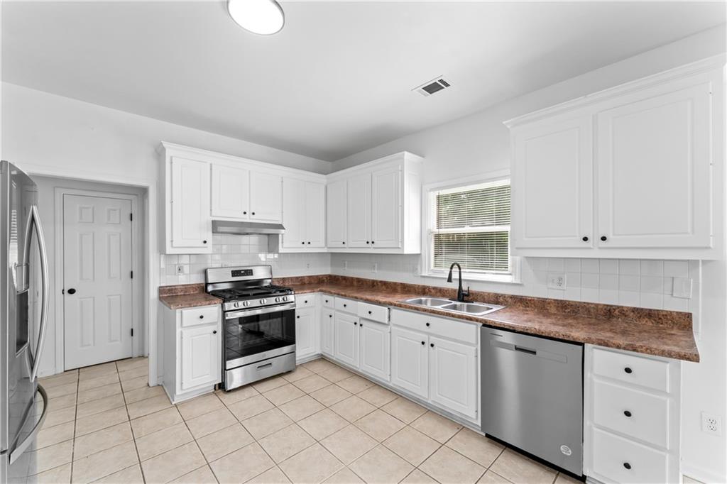 4267 Azalea Walk Ellenwood, GA 30294 - Photo 6 of 24 a kitchen with granite countertop white cabinets white stainless steel appliances with a sink and dishwasher