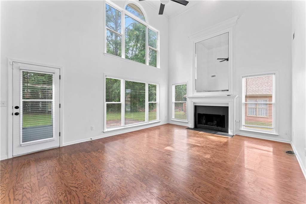 4267 Azalea Walk Ellenwood, GA 30294 - Photo 10 of 24 an empty room with wooden floor fireplace and windows
