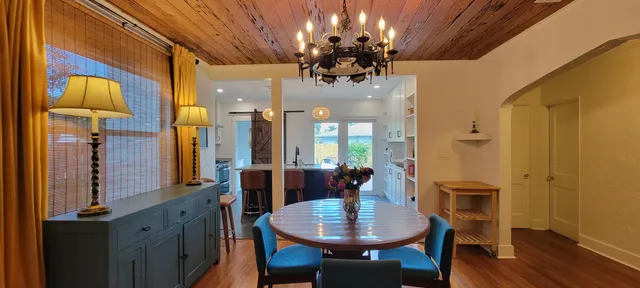 a view of a dining room with furniture a chandelier and wooden floor