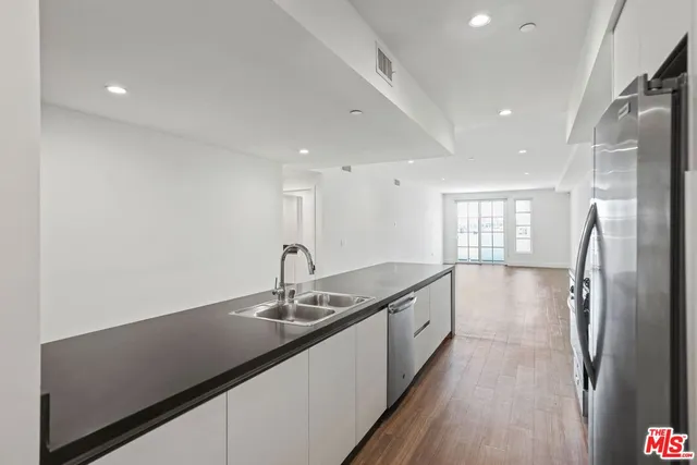 a kitchen with stainless steel appliances granite countertop a sink and a refrigerator