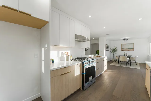 a kitchen with white cabinets and stainless steel appliances