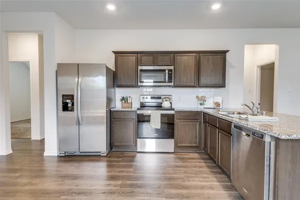 a kitchen with stainless steel appliances granite countertop a refrigerator and a stove