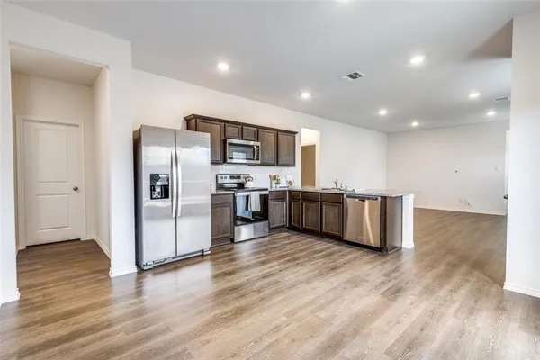 a kitchen with stainless steel appliances a refrigerator and a microwave
