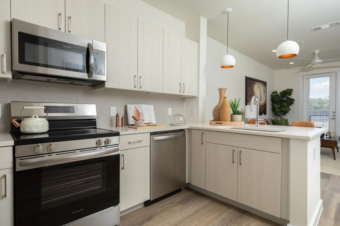 1690 North Loop, Unit 128 Houston, TX 77009 - Photo 7 of 28 a kitchen with stainless steel appliances granite countertop a stove and a microwave