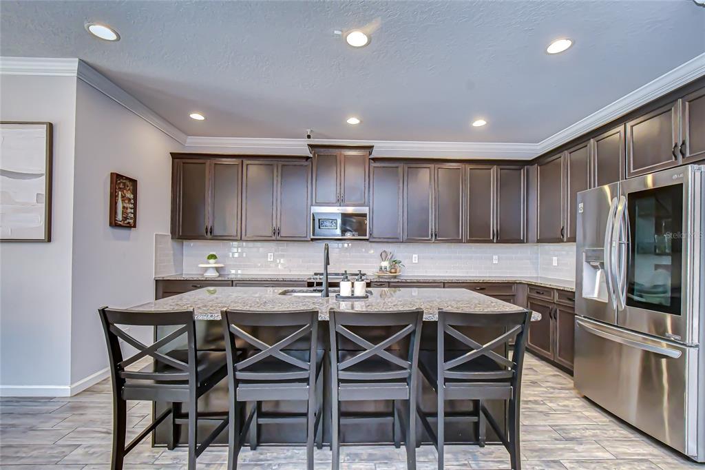 11724 Wrought Pine Loop Riverview, FL 33569 - Photo 11 of 44 a kitchen with a table and chairs in it
