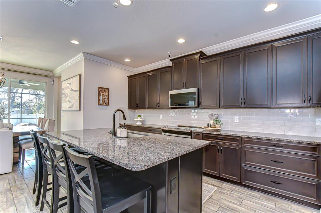 11724 Wrought Pine Loop Riverview, FL 33569 - Photo 12 of 44 a kitchen with a sink a stove cabinets counter space and appliances