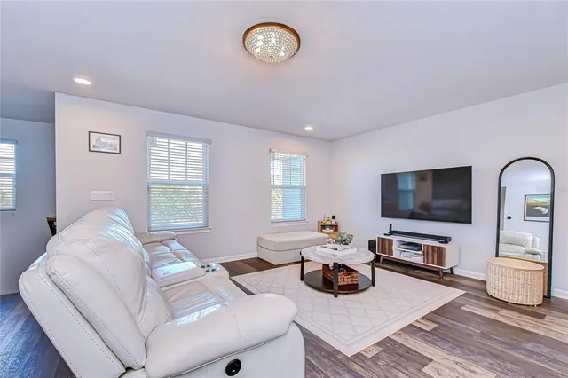 a living room with furniture a flat screen tv and a window