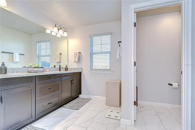 a spacious bathroom with a double vanity sink a mirror and a bathtub