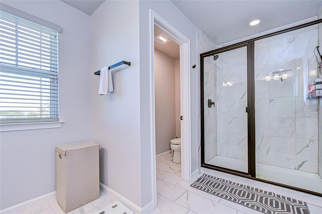 11724 Wrought Pine Loop Riverview, FL 33569 - Photo 23 of 44 a bathroom with a glass shower door