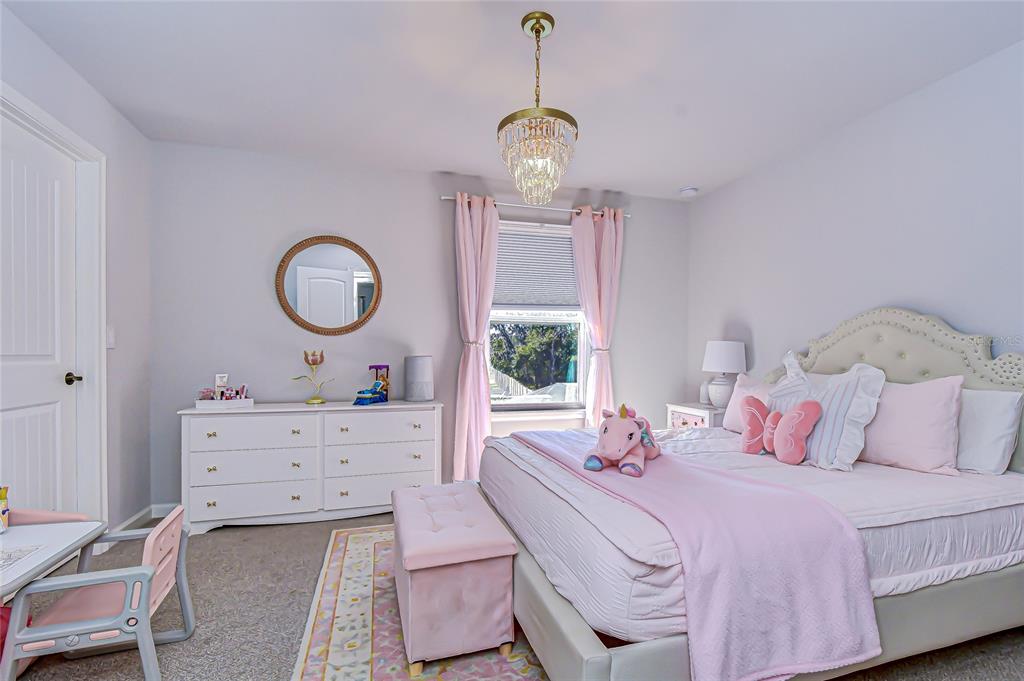 11724 Wrought Pine Loop Riverview, FL 33569 - Photo 28 of 44 a bedroom with a bed and chandelier