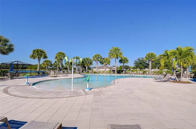 a swimming pool with outdoor seating and yard in back