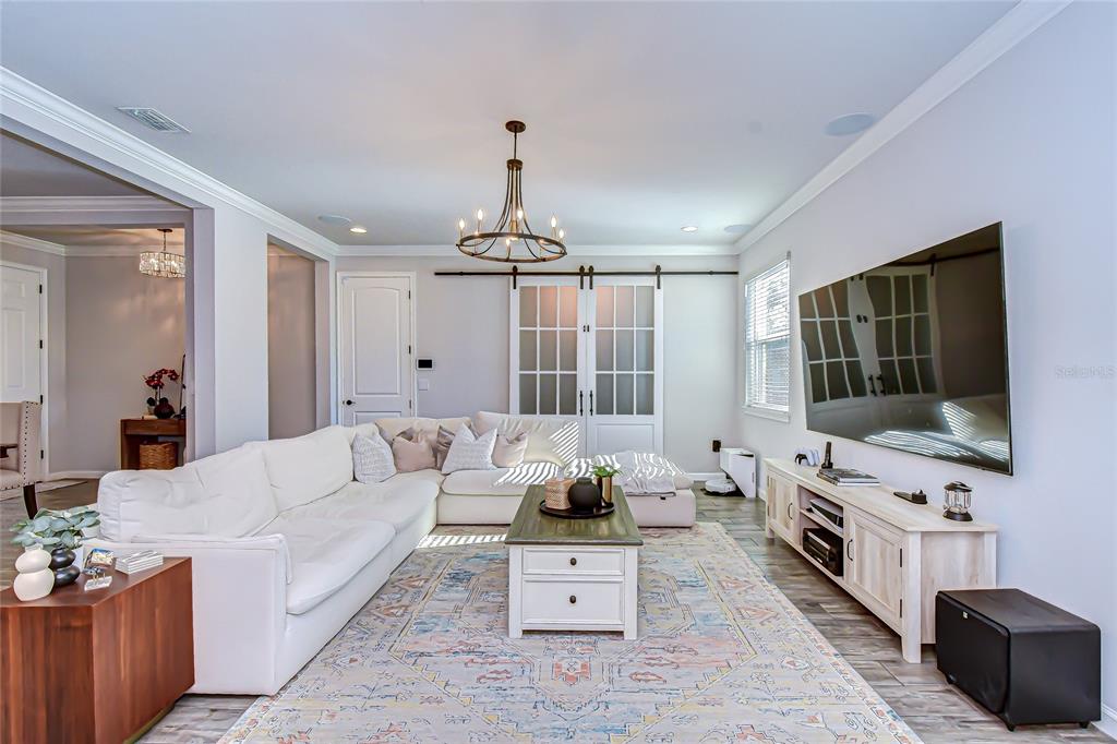 11724 Wrought Pine Loop Riverview, FL 33569 - Photo 9 of 44 a living room with furniture a flat screen tv and a chandelier