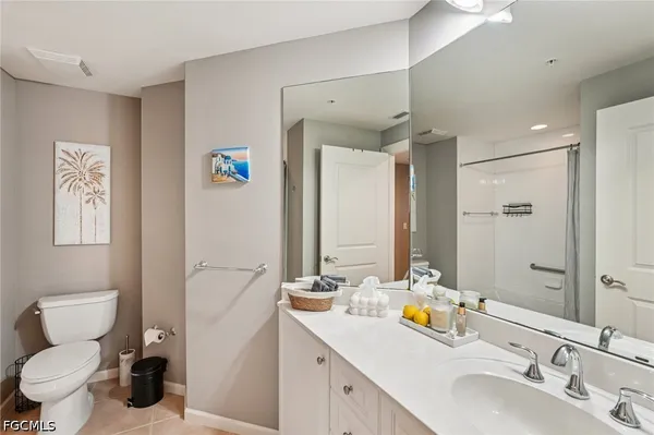 a bathroom with a double vanity sink mirror and toilet