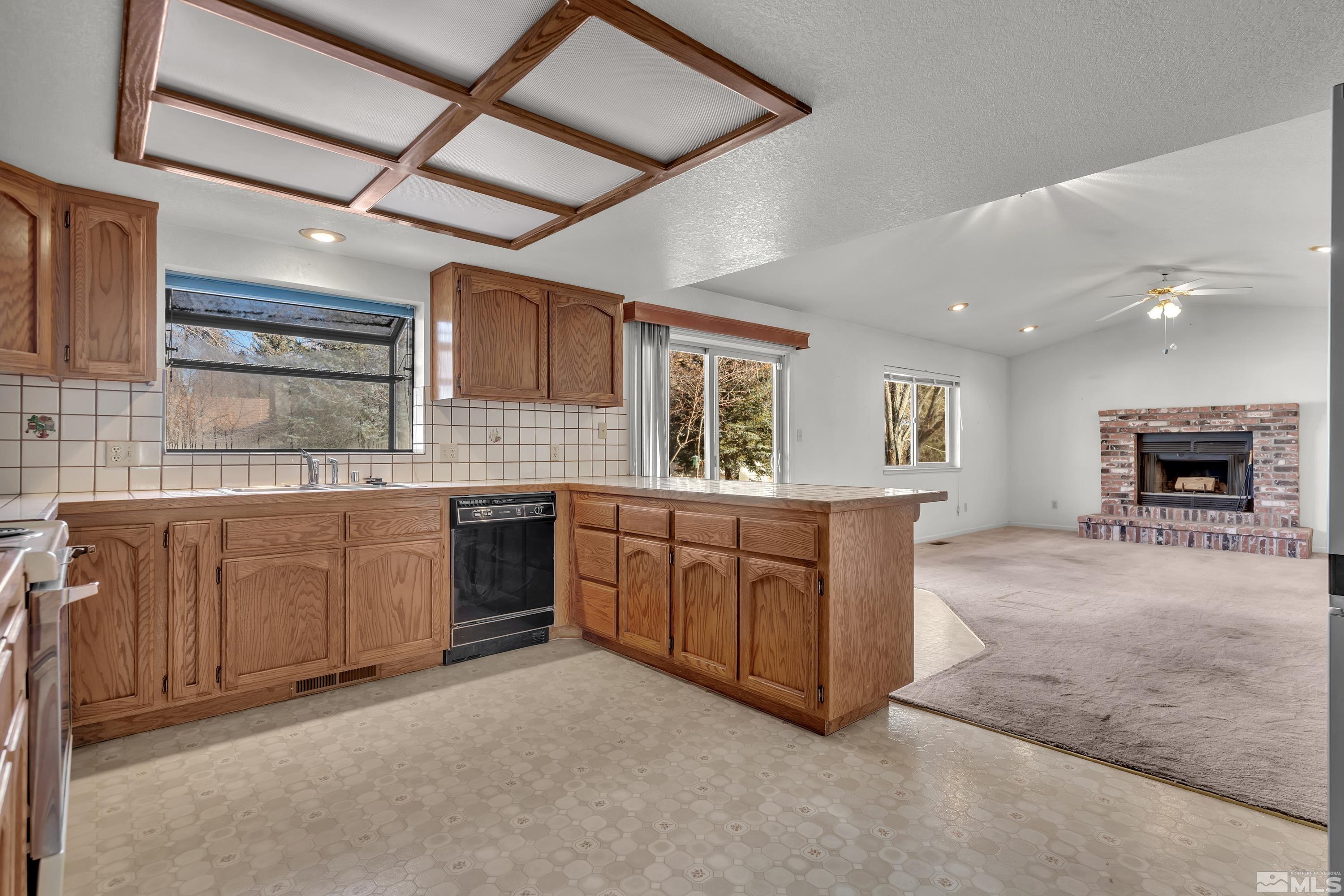 1105 West Huffaker Lane Reno, NV 89511 - Photo 4 of 20 a kitchen with sink cabinets and window