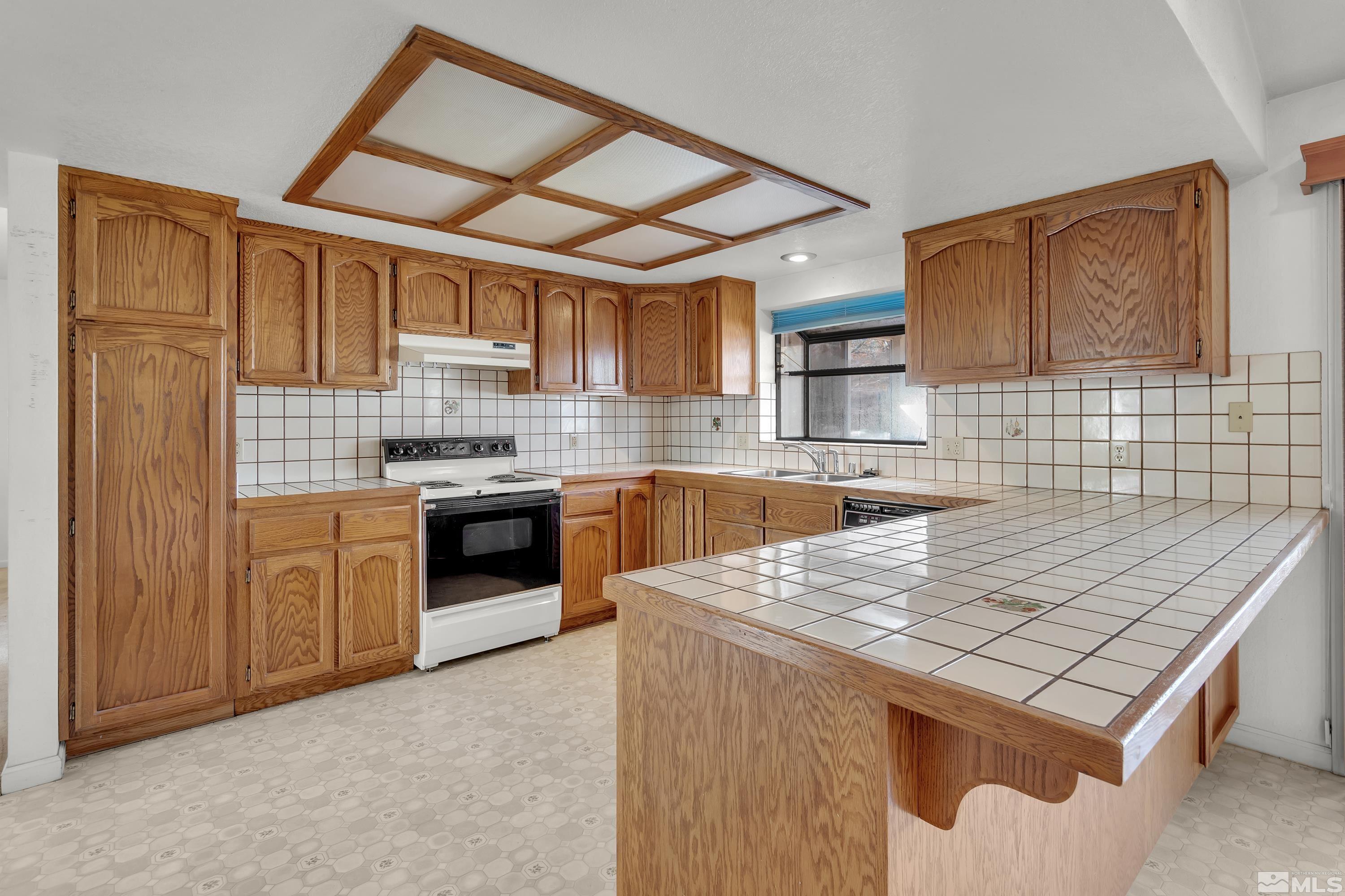 1105 West Huffaker Lane Reno, NV 89511 - Photo 5 of 20 a kitchen with stainless steel appliances granite countertop a stove sink and cabinets