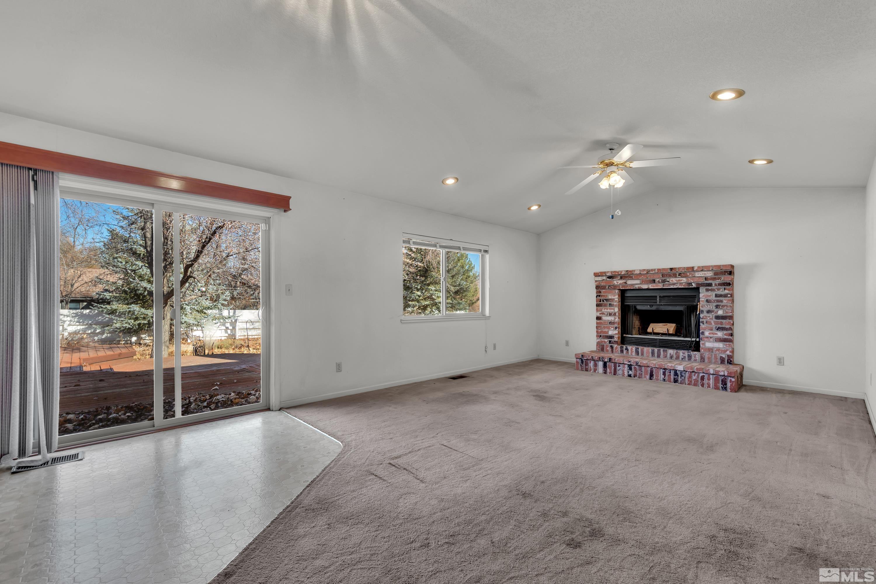 1105 West Huffaker Lane Reno, NV 89511 - Photo 6 of 20 an empty room with windows and fireplace