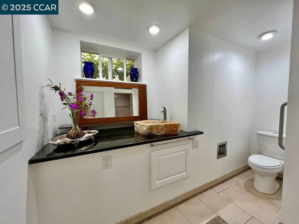 449 Burnett Avenue, Unit A San Francisco, CA 94131 - Photo 5 of 9 a bathroom with a sink a toilet and a mirror