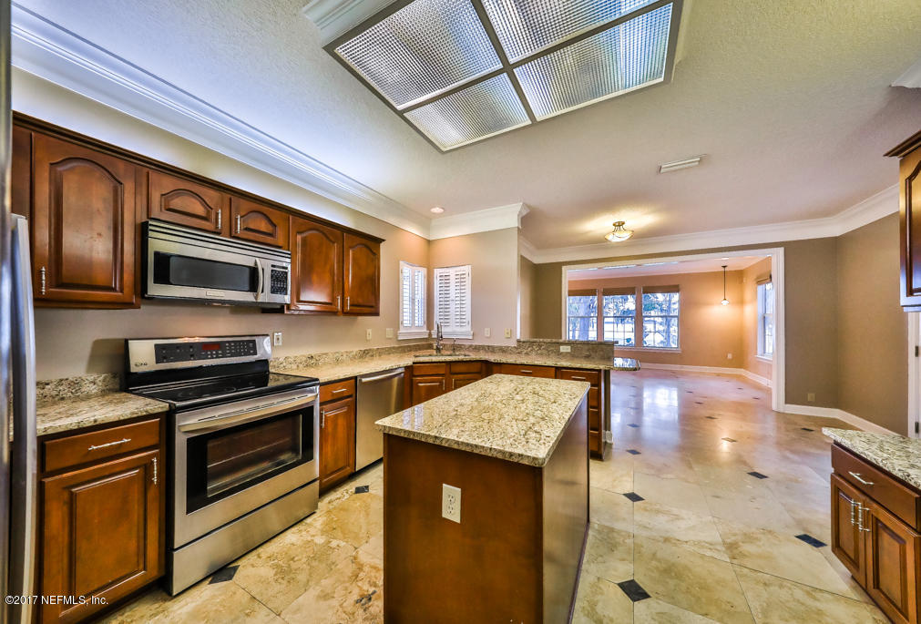 104 River's Edge Road North St. Augustine, FL 32092 - Photo 8 of 18 a kitchen with stainless steel appliances granite countertop a stove top oven a sink dishwasher a dining table and chairs with wooden floor