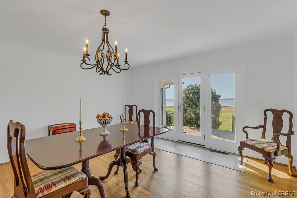1057 Monaskon Road Lancaster, VA 22503 - Photo 23 of 43 Dining space with light tile flooring and a notable chandelier
