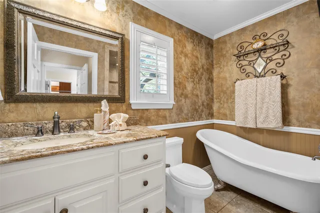 a bathroom with a granite countertop toilet sink and mirror
