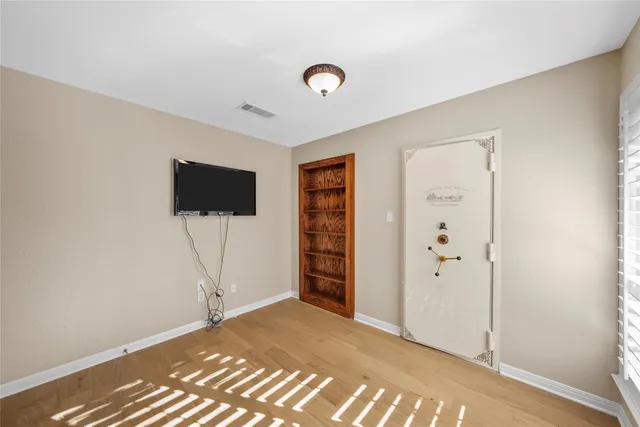 a view of a livingroom with wooden floor and a flat screen tv