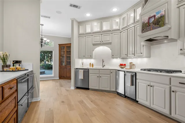 a kitchen with granite countertop a sink cabinets and stainless steel appliances