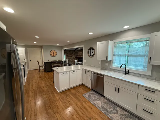 a kitchen with a sink and wooden floor