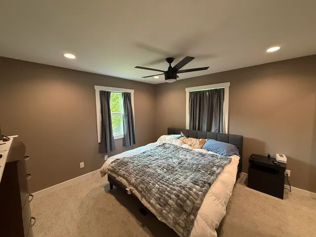 a bedroom with a large bed and a chandelier