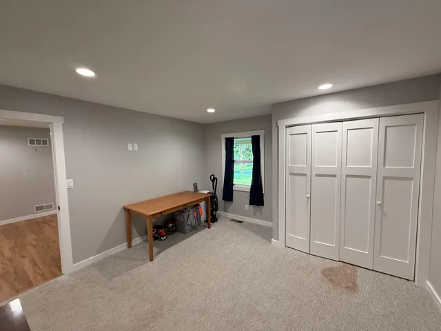 an empty room with windows and closet