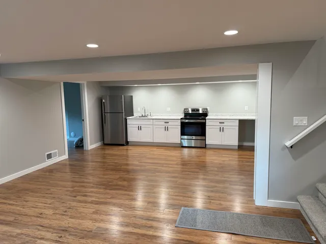 a view of a kitchen with a refrigerator and a stove top oven