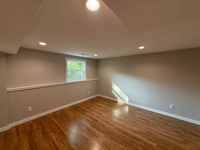 a view of empty room with wooden floor