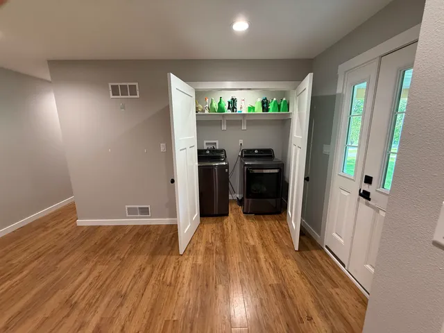 wooden floor in an empty room with a kitchen