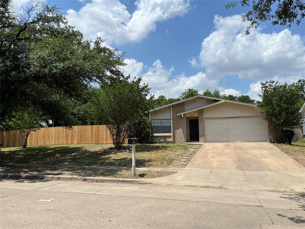 View of front of house with brick siding, an attached garage, and concrete driveway