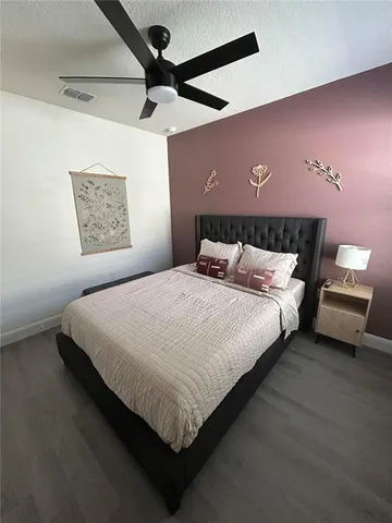 a bedroom with a bed and a ceiling fan