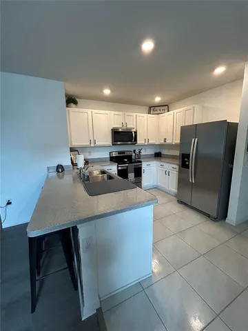 a kitchen with refrigerator and chairs