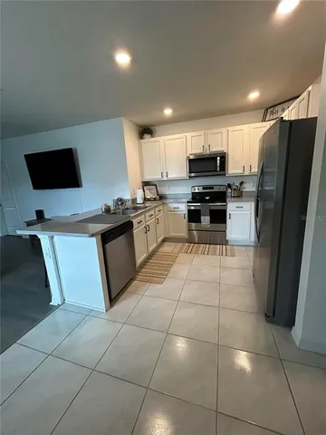 a kitchen with granite countertop a refrigerator and a stove top oven