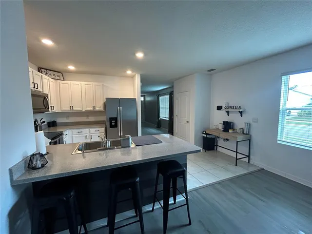 a kitchen with a dining table chairs and refrigerator