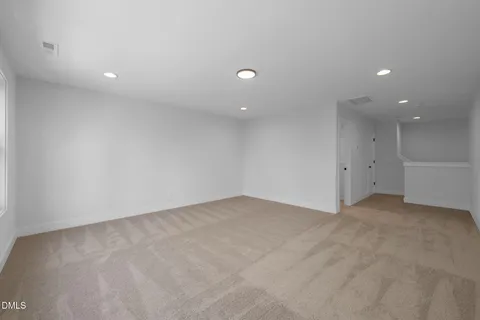 an empty room with white wall and natural light