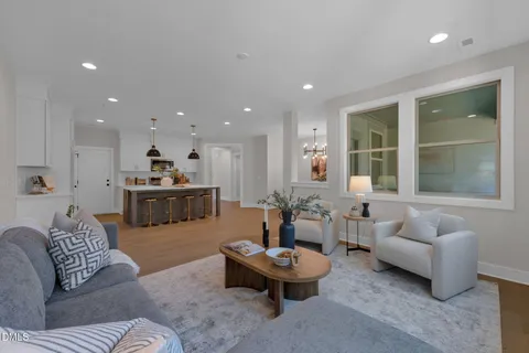 a living room with furniture and view of kitchen