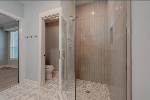 a bathroom with a toilet and a shower
