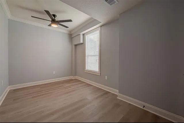 an empty room with a window and a fan