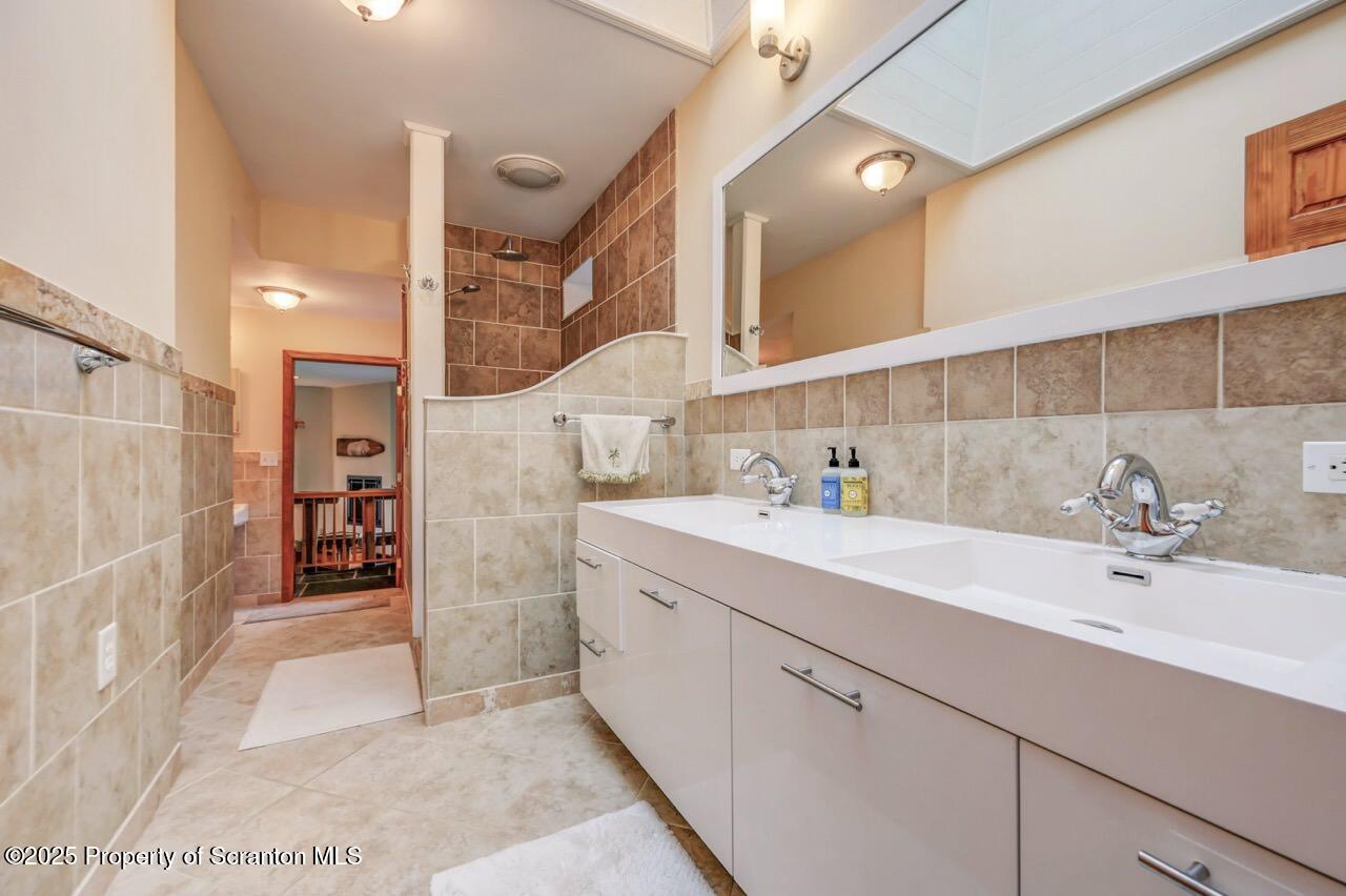 242 Shore Drive Hop Bottom, PA 18824 - Photo 62 of 120 a bathroom with a sink a mirror and a shower