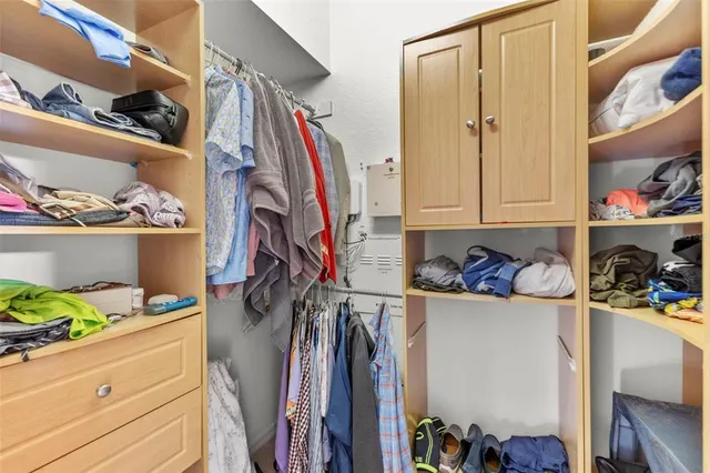 a view of walk in closet with clothes and shoes