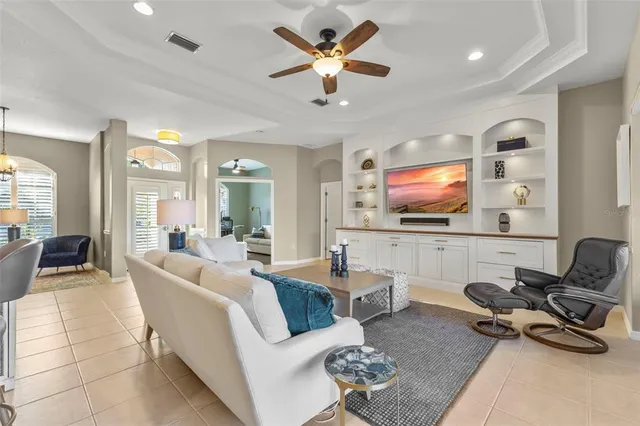 a living room with furniture a flat screen tv and kitchen view