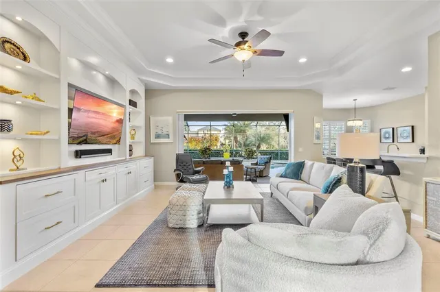 a living room with furniture a flat screen tv and a large window