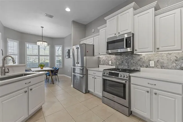 a kitchen with granite countertop a sink stainless steel appliances and cabinets