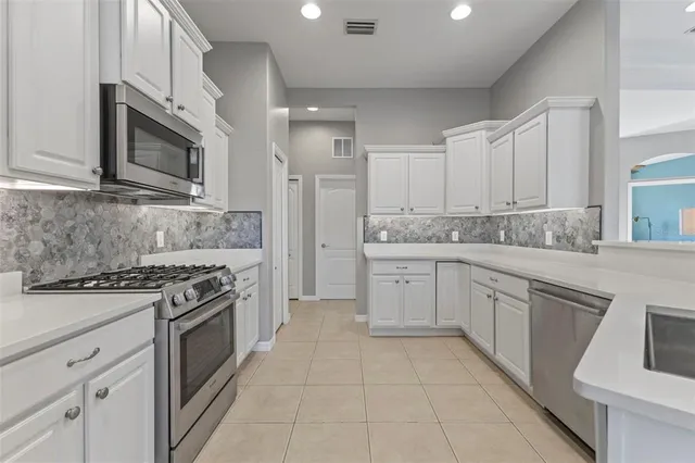 a kitchen with stainless steel appliances granite countertop a stove top oven microwave and cabinets