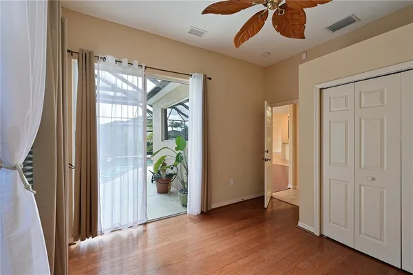 a view of a hallway with wooden floor and a chandelier