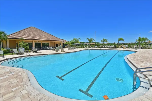 a view of a house with pool and chairs