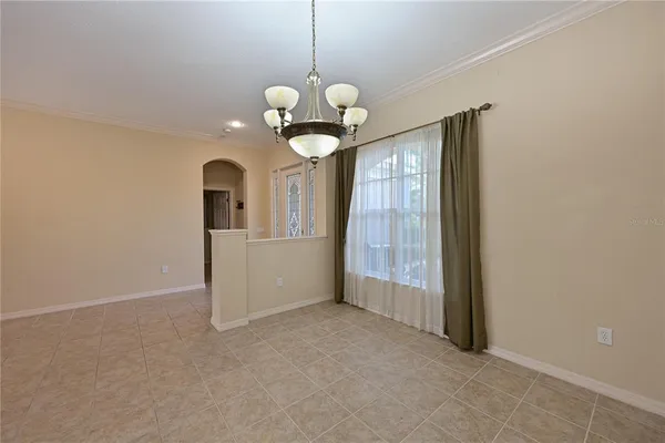 a view of a room with a chandelier fan and windows